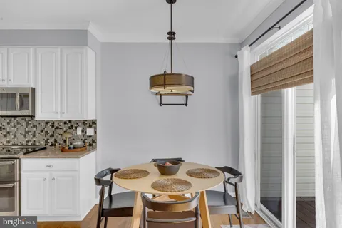 a kitchen with stainless steel appliances granite countertop a table and chairs in it