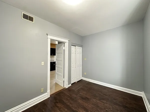 a view of an empty room with wooden floor