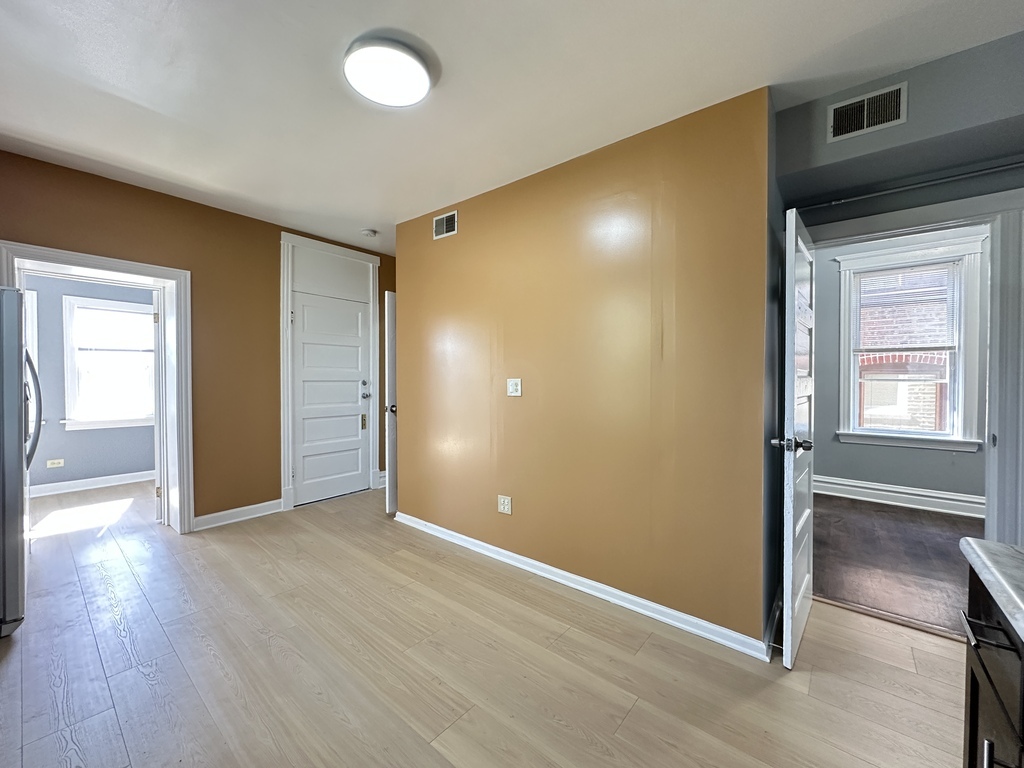 2713 West 16th Street, Unit 3 Chicago, IL 60608 - Photo 7 of 20 a view of an empty room with wooden floor and a window
