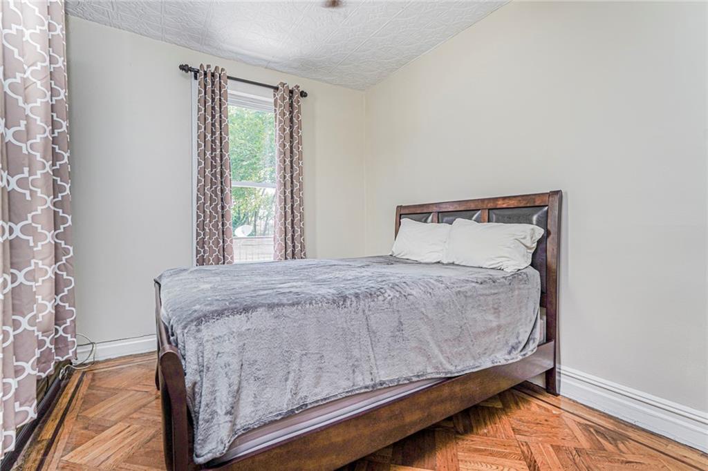 106 Village Road South Brooklyn, NY 11223 - Photo 16 of 42 a bed sitting in a bedroom next to a window