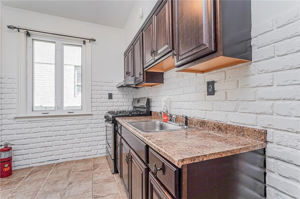 106 Village Road South Brooklyn, NY 11223 - Photo 26 of 42 a kitchen with granite countertop a sink a stove and cabinets