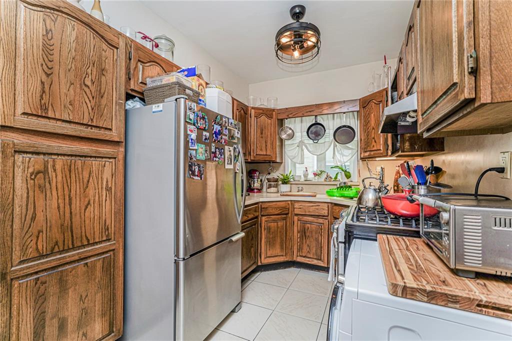 106 Village Road South Brooklyn, NY 11223 - Photo 31 of 42 a kitchen with stainless steel appliances granite countertop a refrigerator and a stove