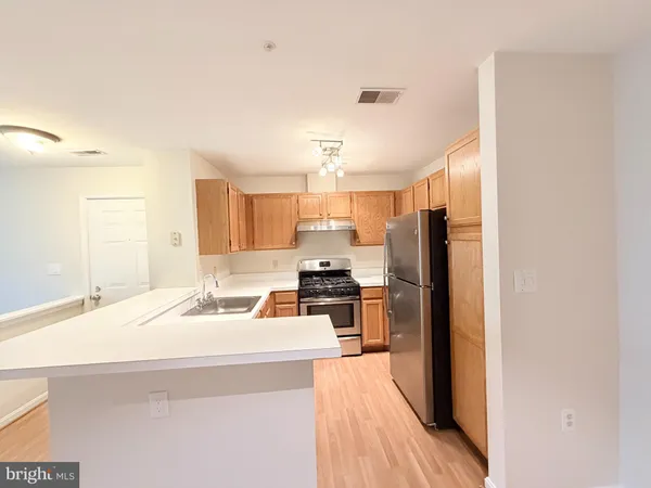 a kitchen with stainless steel appliances a refrigerator sink and stove