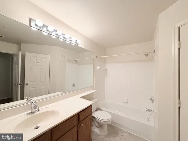 a bathroom with a sink a toilet a large mirror and shower