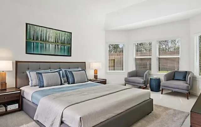 a bedroom with bed couch and window