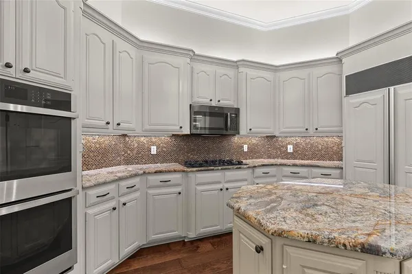 a kitchen with stainless steel appliances granite countertop a stove a refrigerator and a microwave