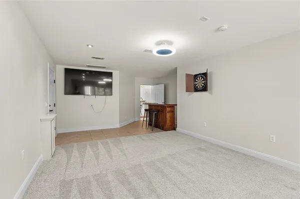 a view of an empty room with window and a flat screen tv