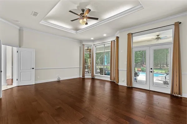 a view of an empty room with a window and wooden floor