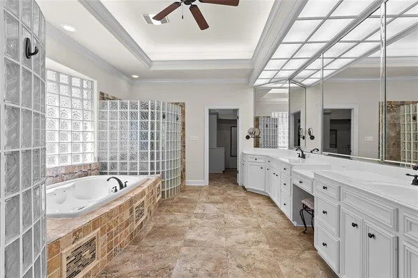 a large white bathroom with a large tub sink shower and mirror