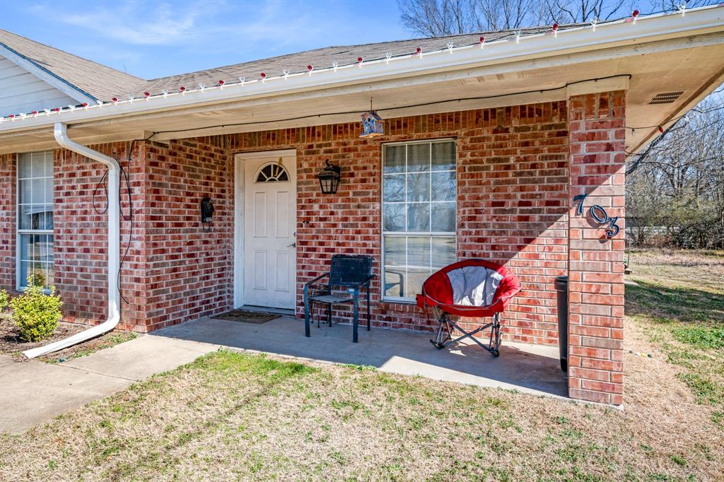 701 Southwest 1st Street Cooper, TX 75432 - Photo 11 of 22 a view of a patio with table and chairs with wooden floor and fence