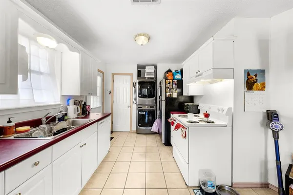 a kitchen with a refrigerator and white cabinets