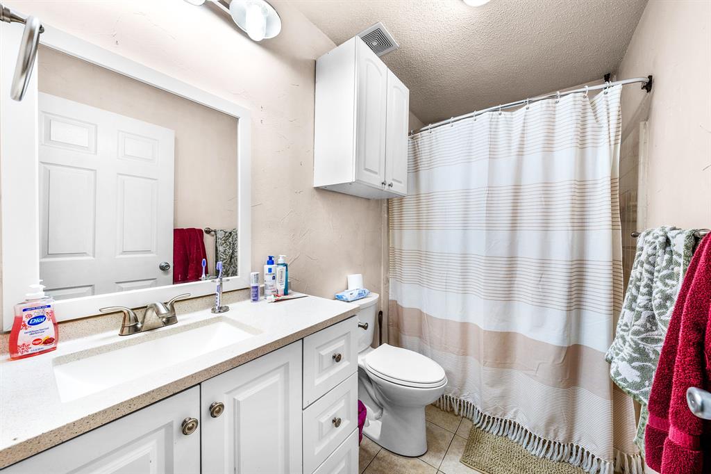 701 Southwest 1st Street Cooper, TX 75432 - Photo 10 of 22 a bathroom with a double vanity sink toilet and shower