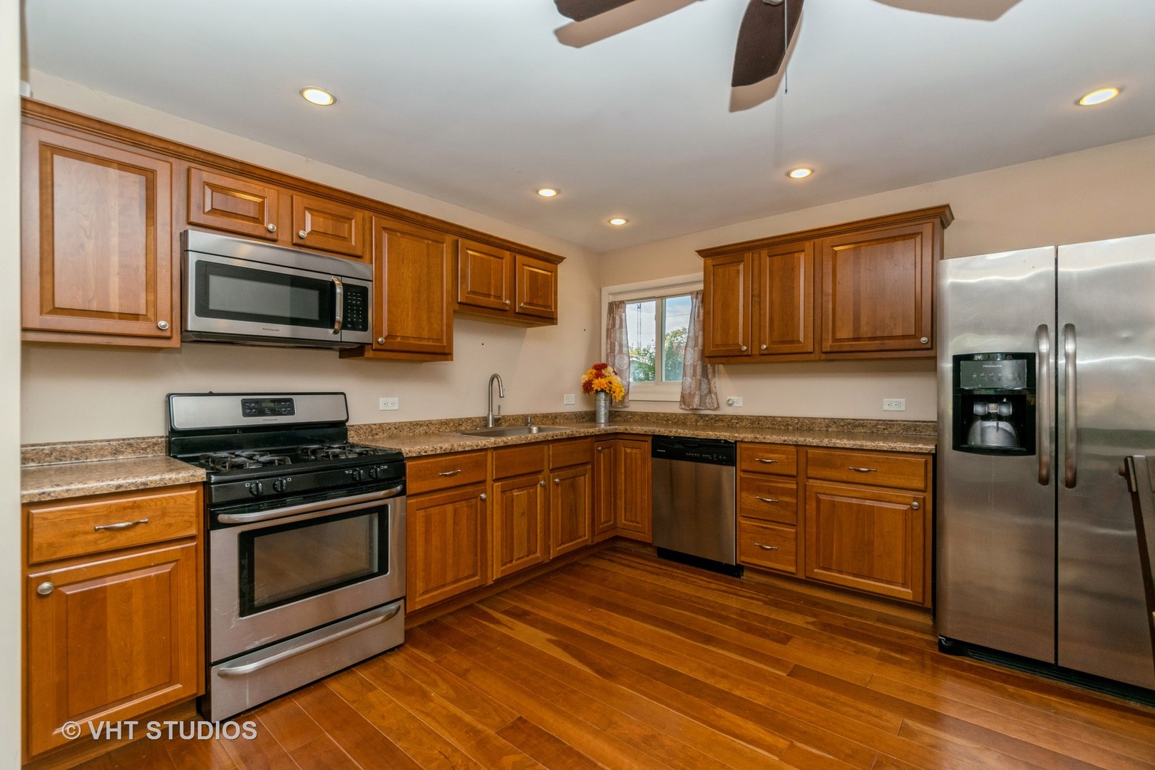 317 Stuart Road Lockport, IL 60441 - Photo 6 of 16 a kitchen with stainless steel appliances granite countertop a stove top oven a sink dishwasher a refrigerator and a microwave oven on the wooden floor