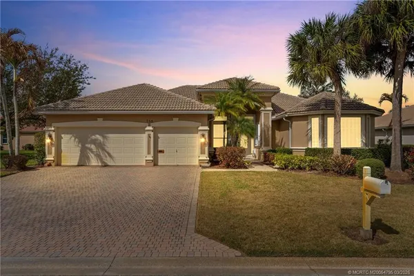 a front view of house with yard and trees around