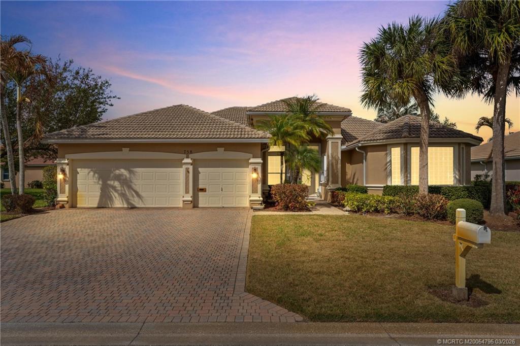 a front view of house with yard and trees around