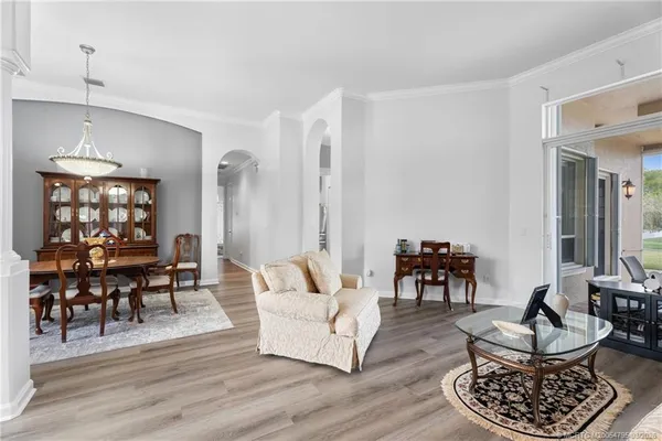 a living room with furniture and a dining table with wooden floor