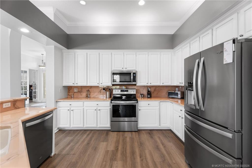 758 Southwest Blue Stem Way Stuart, FL 34997 - Photo 13 of 49 a kitchen with a refrigerator stove and sink