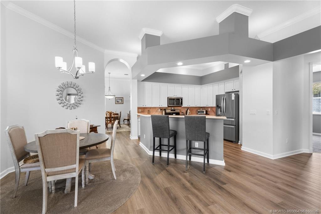 758 Southwest Blue Stem Way Stuart, FL 34997 - Photo 15 of 49 a view of a dining room with furniture and wooden floor
