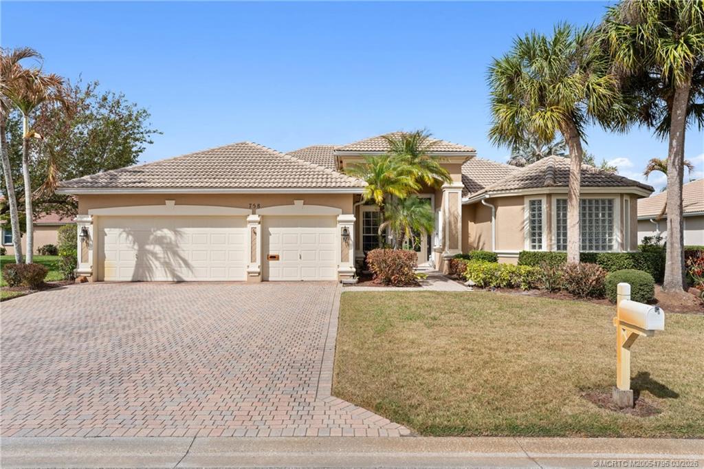 758 Southwest Blue Stem Way Stuart, FL 34997 - Photo 2 of 49 a front view of a house with garden