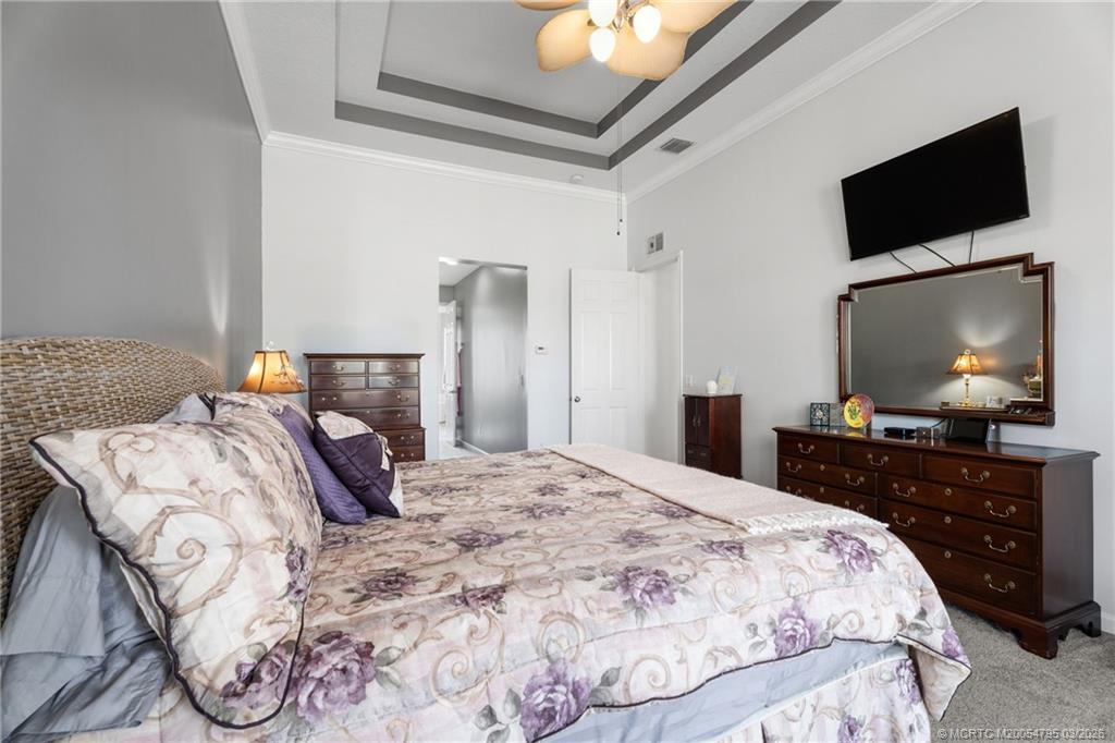 758 Southwest Blue Stem Way Stuart, FL 34997 - Photo 21 of 49 a bedroom with a bed and a flat screen tv