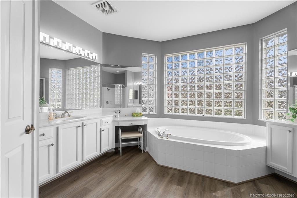 758 Southwest Blue Stem Way Stuart, FL 34997 - Photo 24 of 49 a bathroom with a tub a sink and a large window
