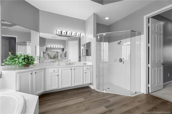 a spacious bathroom with a shower a sink and a mirror