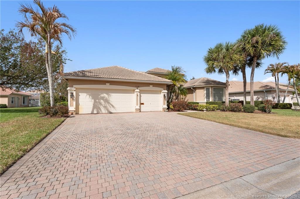 758 Southwest Blue Stem Way Stuart, FL 34997 - Photo 3 of 49 a front view of a house with a yard and garage