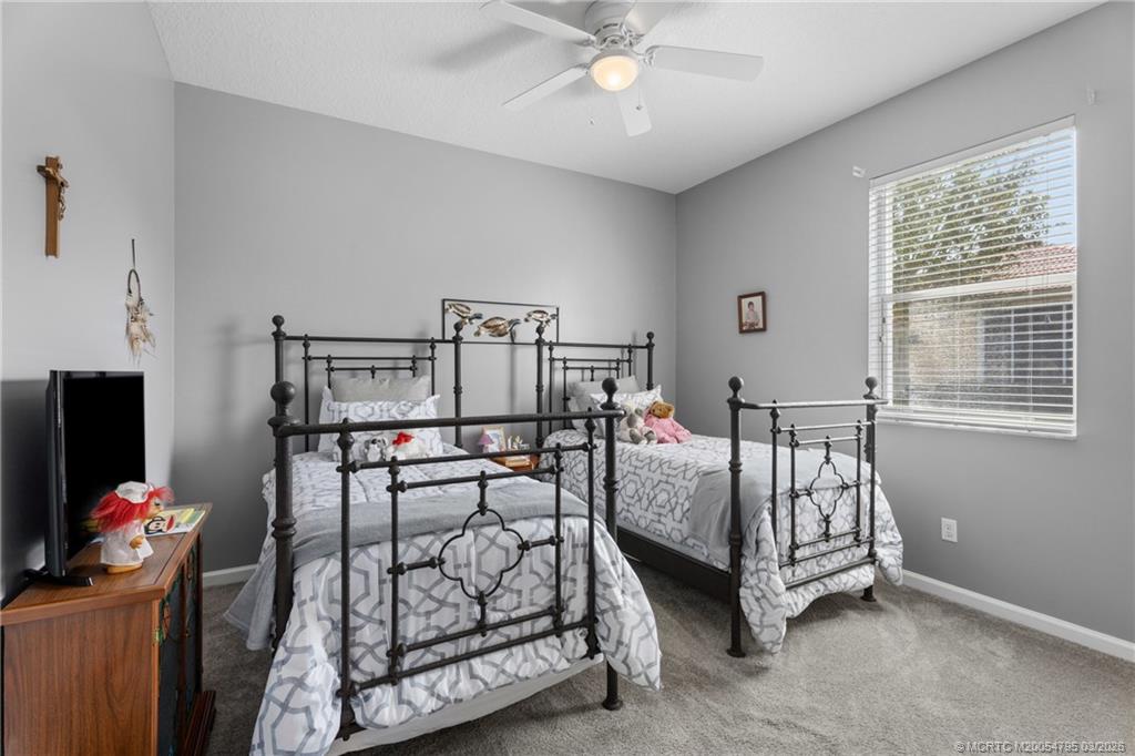 758 Southwest Blue Stem Way Stuart, FL 34997 - Photo 33 of 49 a bedroom with furniture and a chandelier