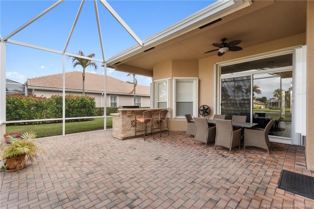 758 Southwest Blue Stem Way Stuart, FL 34997 - Photo 39 of 49 a view of a patio with a table and chairs under an umbrella