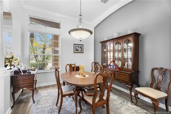 a dining room with furniture a chandelier and wooden floor