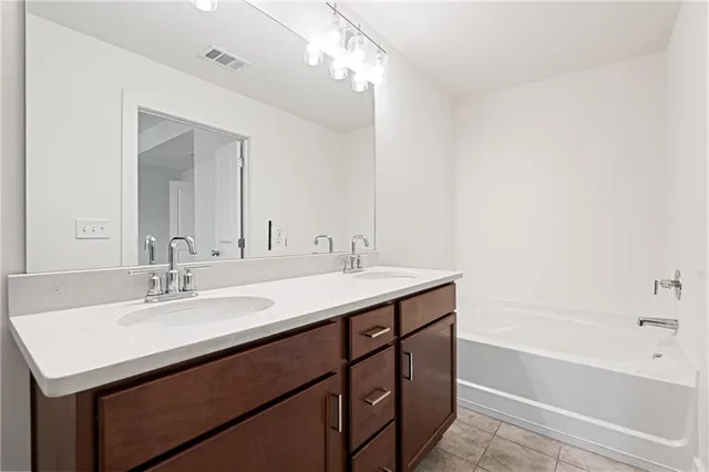 a bathroom with a sink double vanity granite tub and a mirror