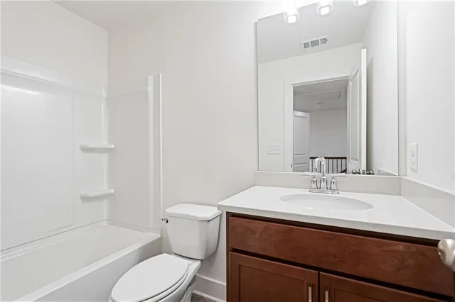 a bathroom with a sink toilet vanity and shower