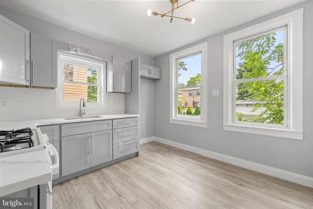 a kitchen with a stove a sink and a window