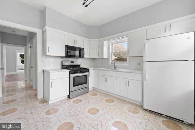 a kitchen with white cabinets and white appliances