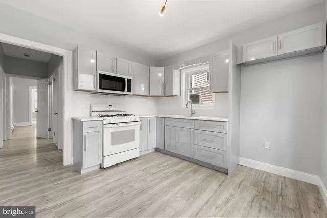 a kitchen with a white stove top oven and cabinets