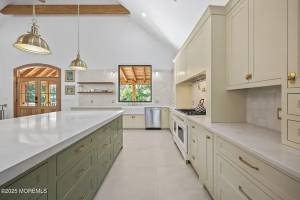 a kitchen with granite countertop white cabinets and white stove