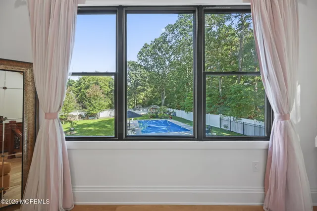 a bedroom with furniture and a large window
