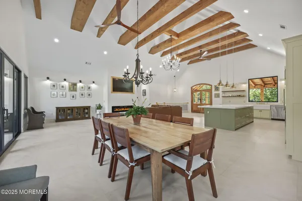a kitchen with stainless steel appliances kitchen island granite countertop a table chairs sink and cabinets