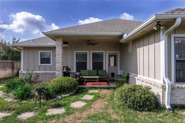 a view of the house with backyard sitting area and garden