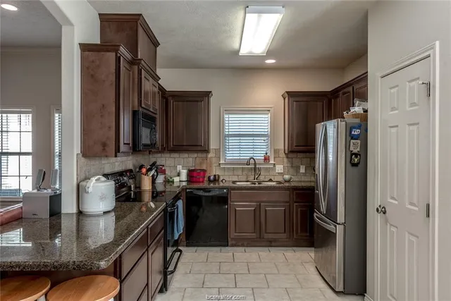 a kitchen with refrigerator and sink