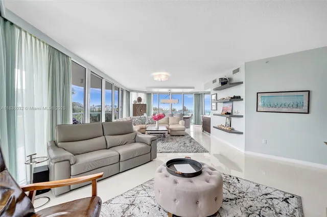 a living room with couches and kitchen view with wooden floor
