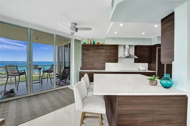 a kitchen with stainless steel appliances kitchen island granite countertop a table chairs microwave and sink