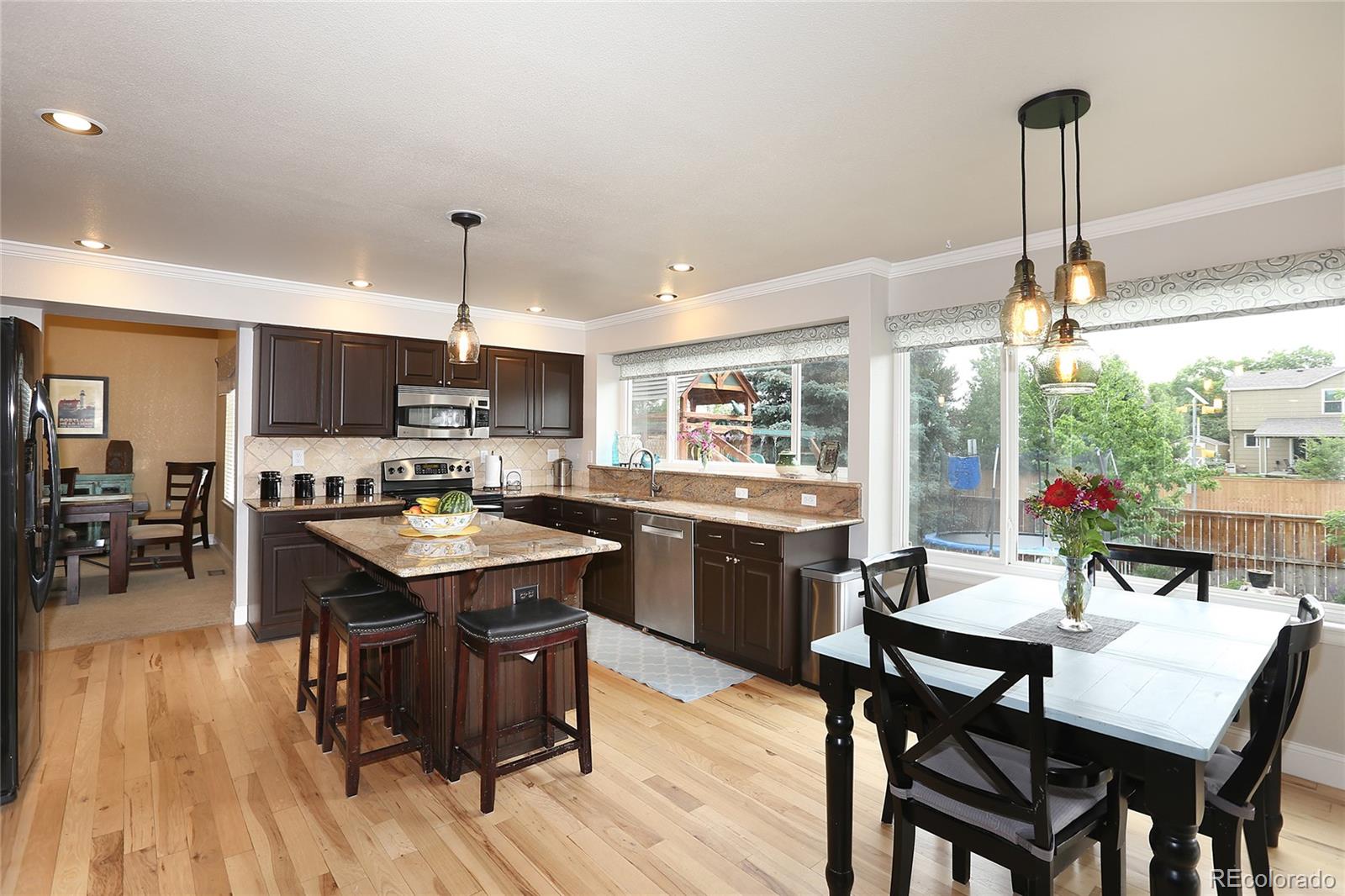 9764 Spring Hill Street Highlands Ranch, CO 80129 - Photo 11 of 32 a kitchen with a table chairs and wooden floor