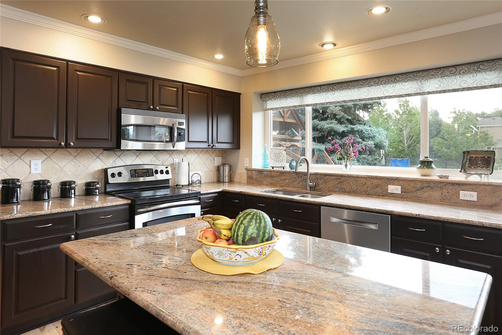 9764 Spring Hill Street Highlands Ranch, CO 80129 - Photo 13 of 32 a kitchen with stainless steel appliances granite countertop a sink a stove and a refrigerator