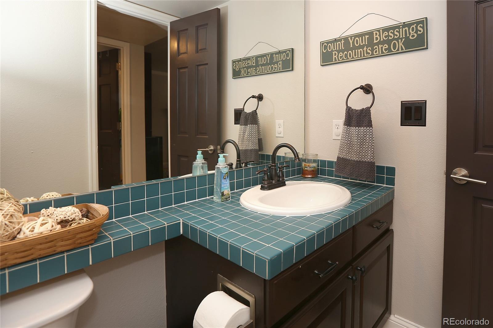 9764 Spring Hill Street Highlands Ranch, CO 80129 - Photo 15 of 32 a bathroom with a granite countertop sink a mirror and a toilet