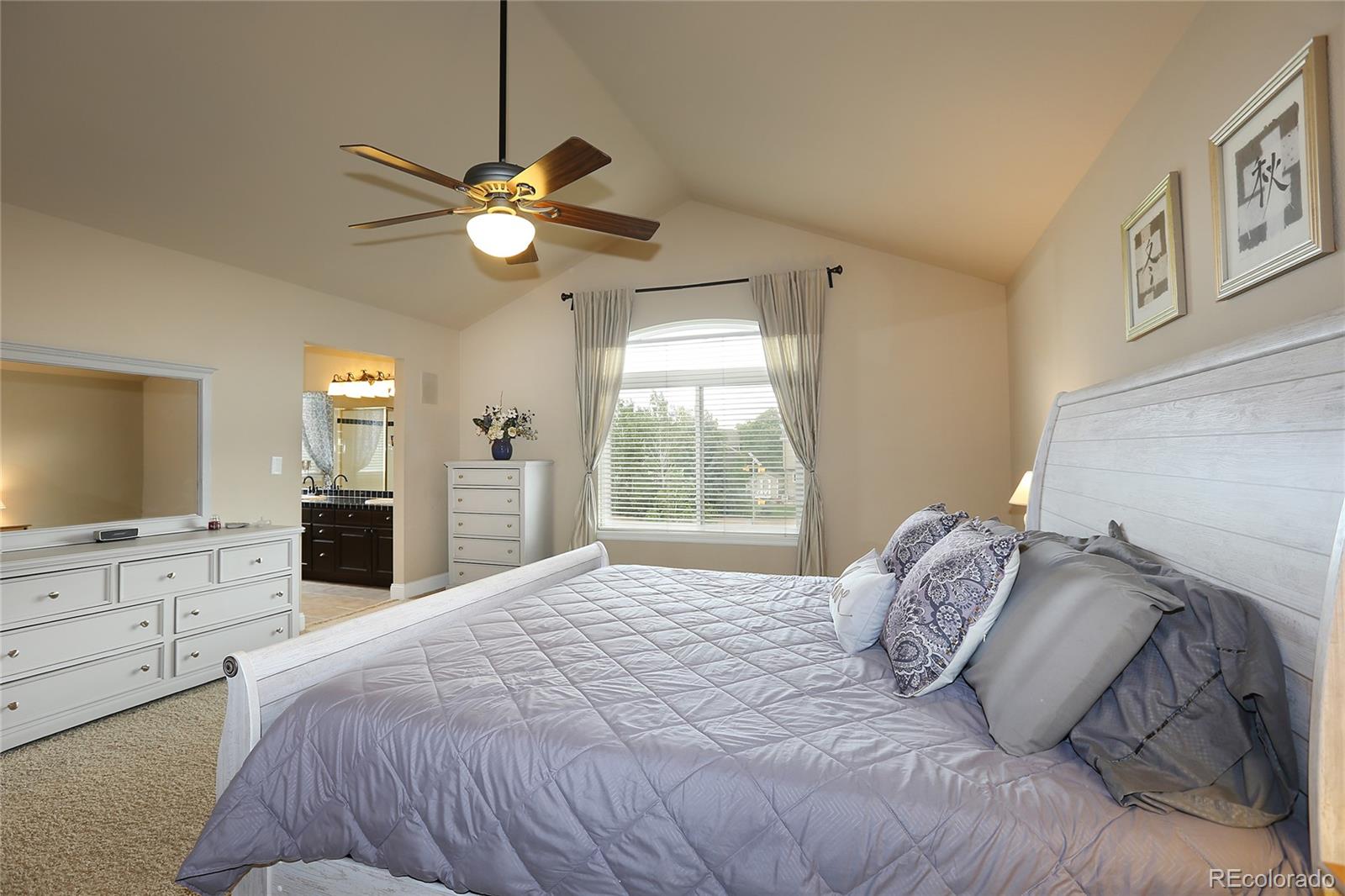 9764 Spring Hill Street Highlands Ranch, CO 80129 - Photo 18 of 32 a bedroom with a large bed and a flat tv screen on dresser