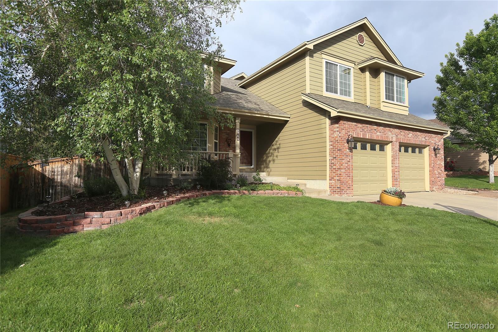 9764 Spring Hill Street Highlands Ranch, CO 80129 - Photo 2 of 32 a front view of a house with a garden