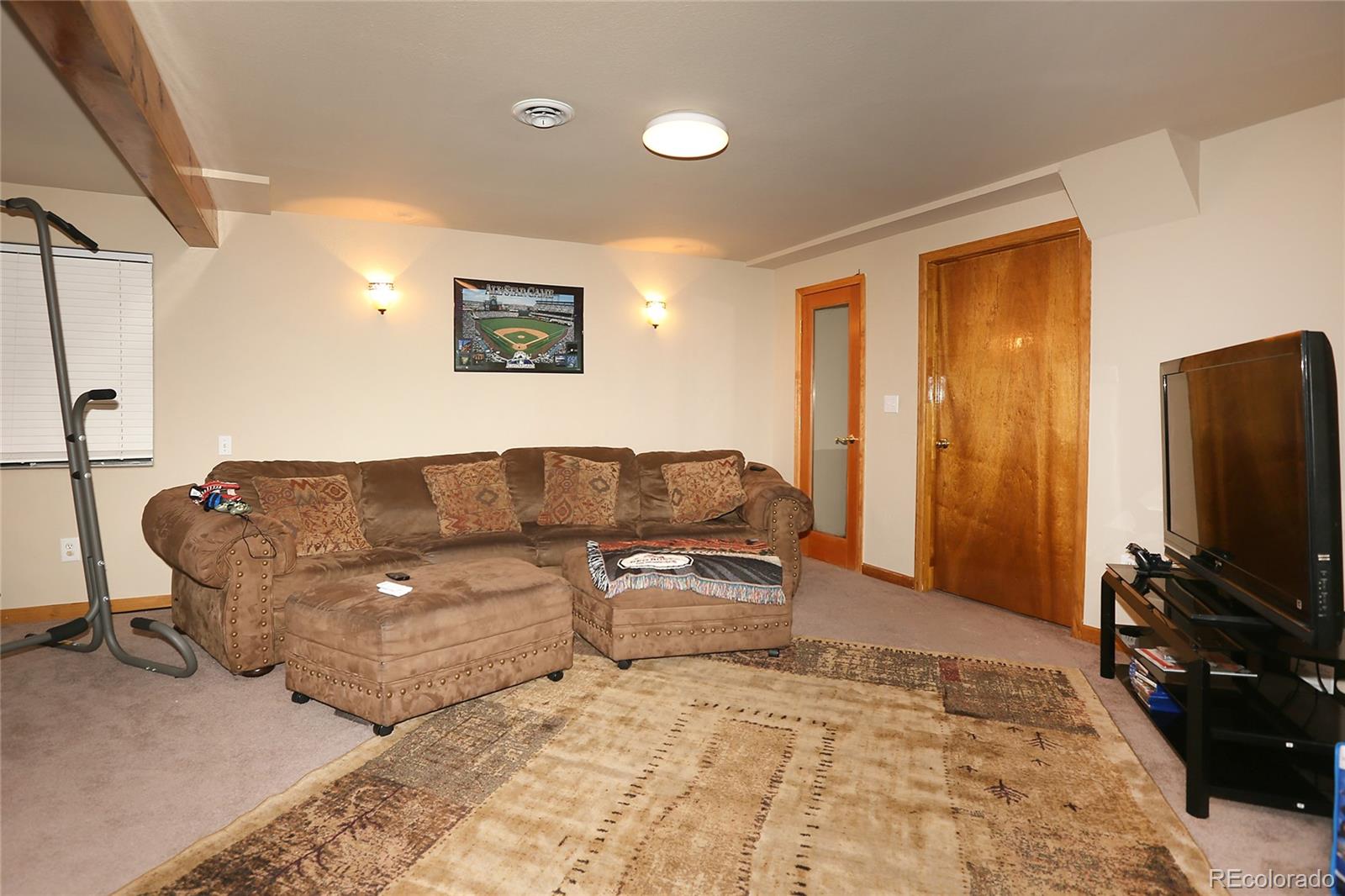 9764 Spring Hill Street Highlands Ranch, CO 80129 - Photo 24 of 32 a living room with furniture and a flat screen tv