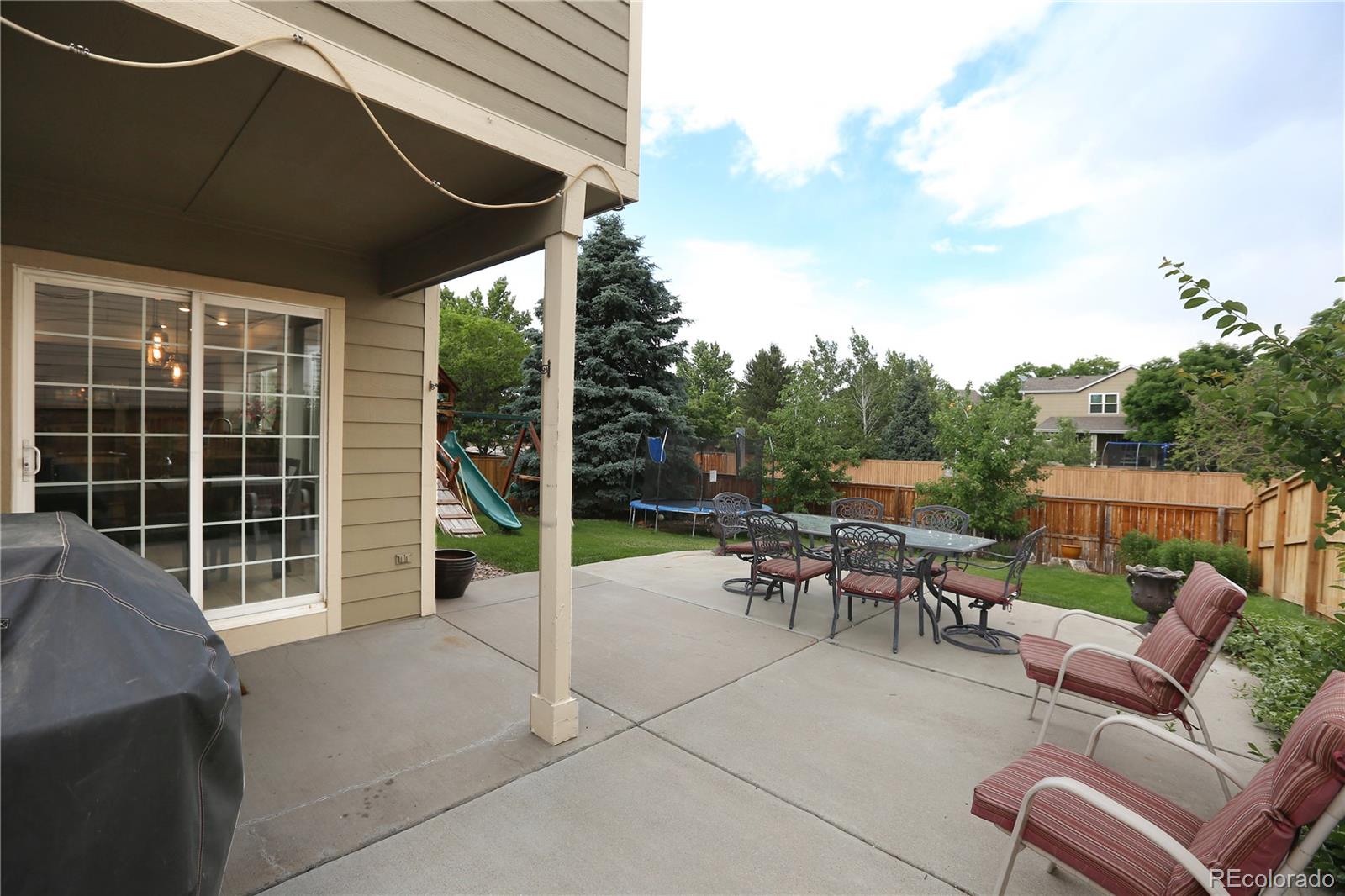 9764 Spring Hill Street Highlands Ranch, CO 80129 - Photo 29 of 32 a view of a patio with table and chairs with wooden floor and fence