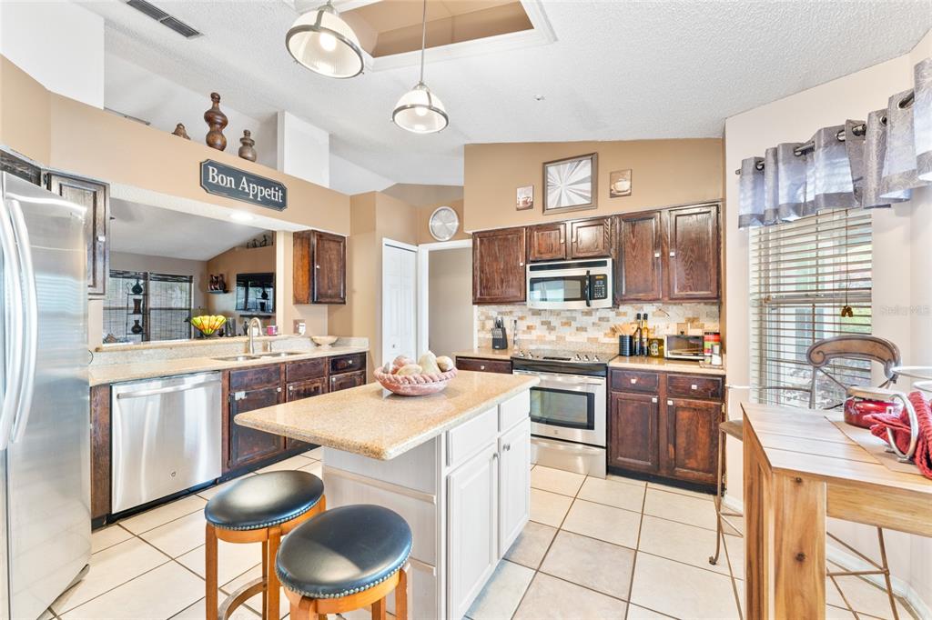 9083 Sable Ridge Court Jacksonville, FL 32244 - Photo 11 of 38 a kitchen with stainless steel appliances a stove a sink dishwasher and cabinets with wooden floor